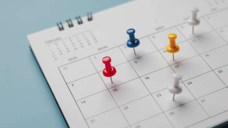 Embroidered red pins on a calendar event Planner calendar,clock to set timetable organize schedule,planning for business meeting or travel planning concept.